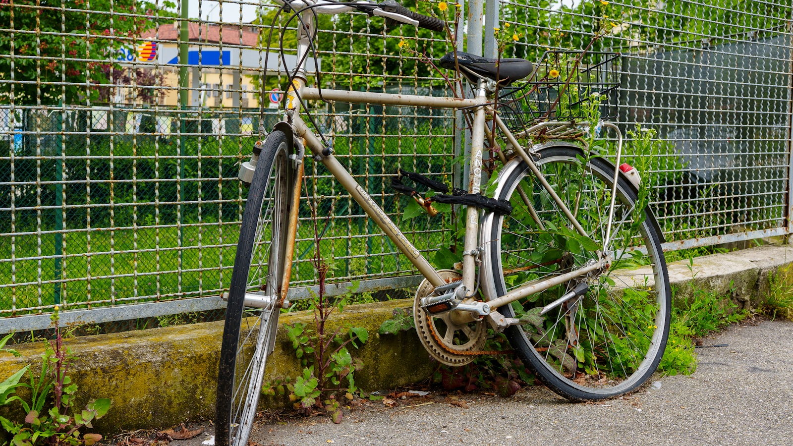 A bicycle locked to a metal fence - security is part of the true cost of e-bike ownership