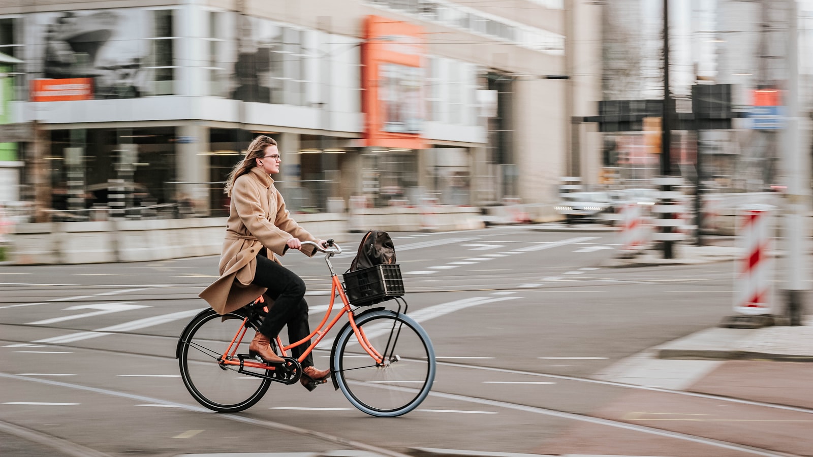A commuter in everyday clothes riding through a city street