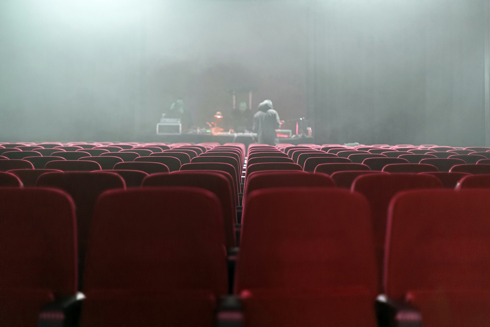 Audience in red theatre seats watching a live performance