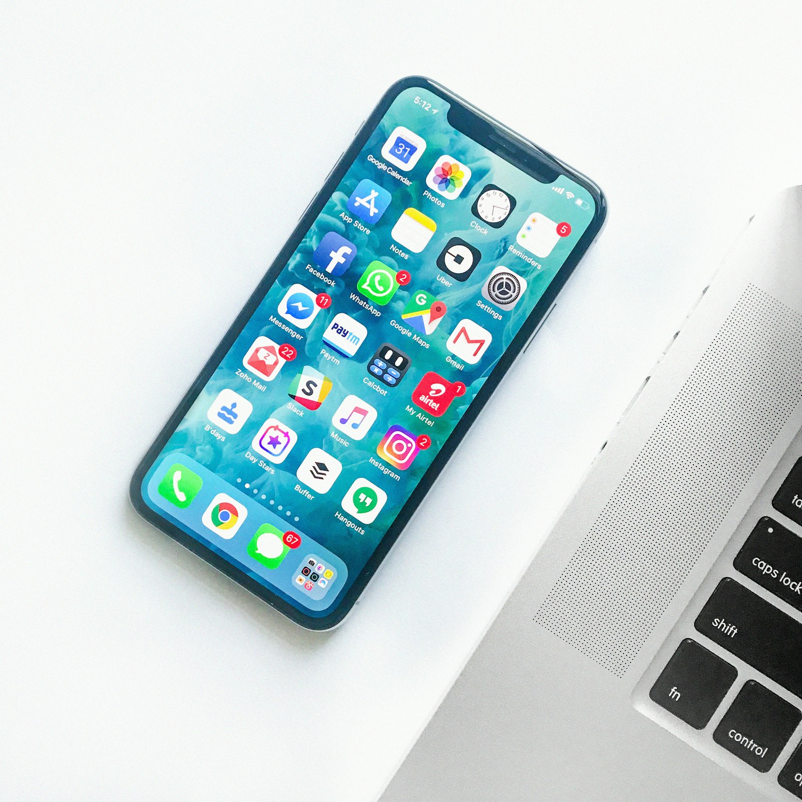 A smartphone on a desk next to a laptop - eSIM setup takes about ten minutes on home Wi-Fi