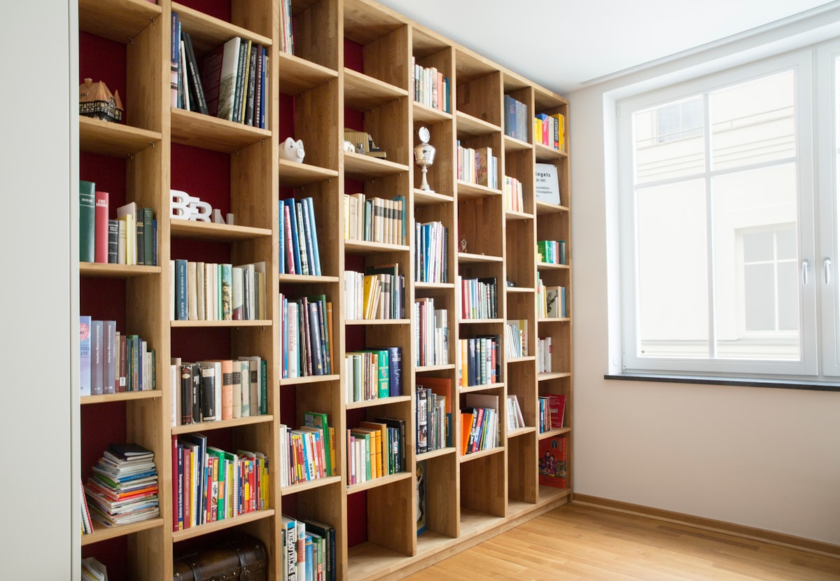 Floor-to-ceiling fitted wooden bookshelves in a British home