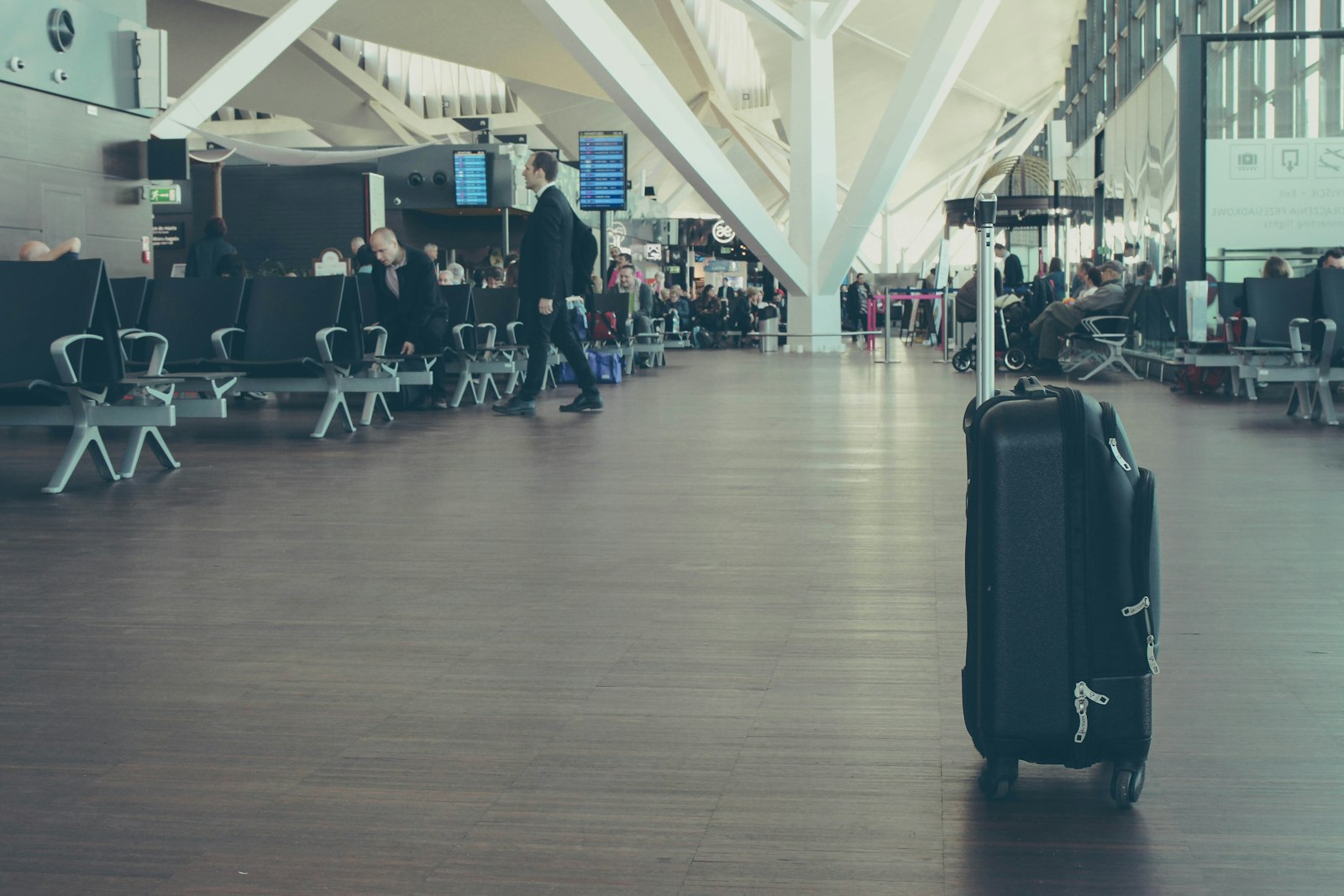 Cabin bags lined up inside an airport terminal - hand luggage rules 2026 vary widely by airline
