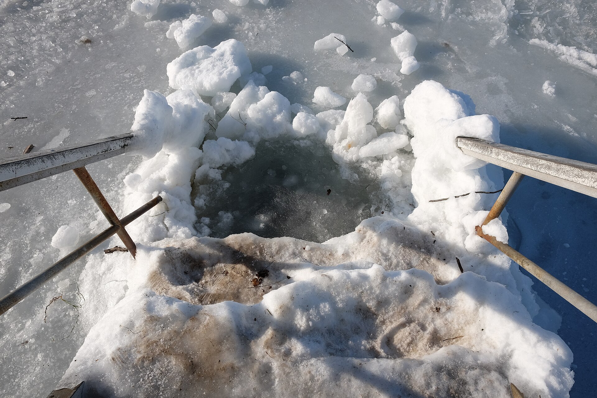 An ice hole cut for winter bathing - ice bath benefits come with real cold shock risks in water below 15C