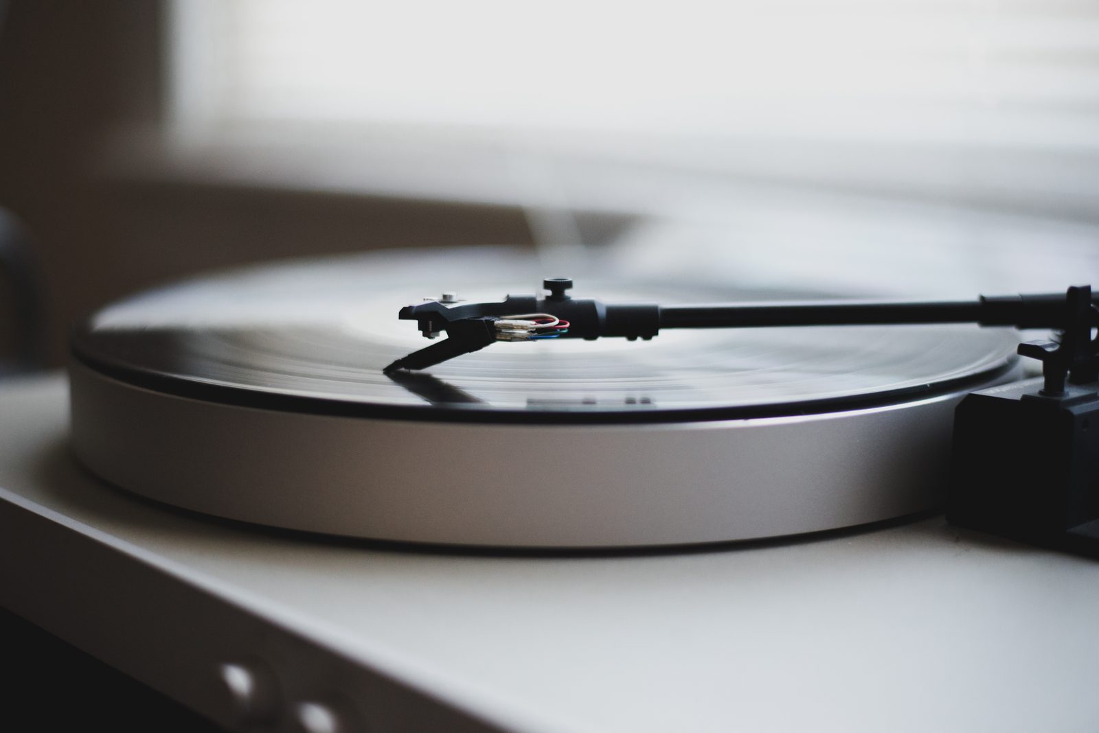 Turntable playing a vinyl record in a warmly lit room