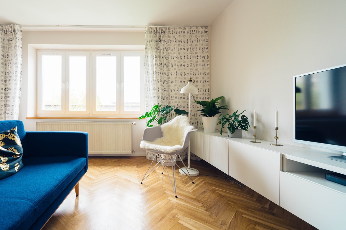 Floor lamp and plants layered in a bright living room corner
