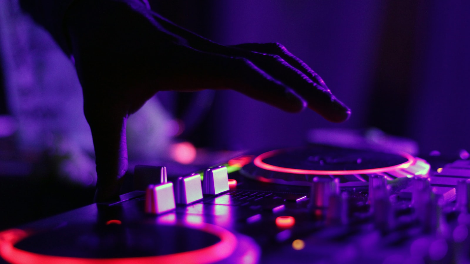 DJ mixing on decks in front of a crowd at Reading and Leeds 2026 style dance stage