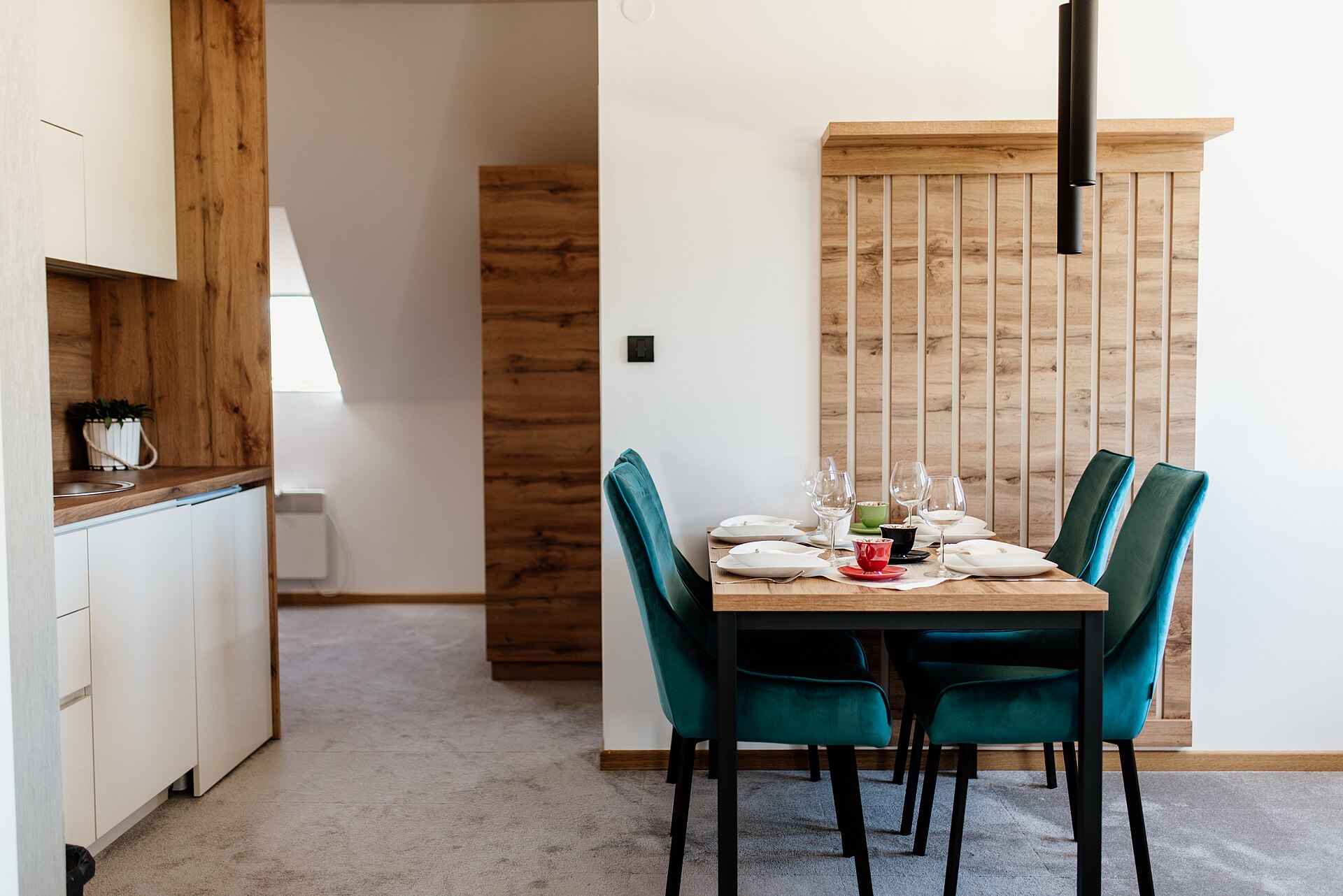 Small dining area zoned from the kitchen with a wooden slat screen
