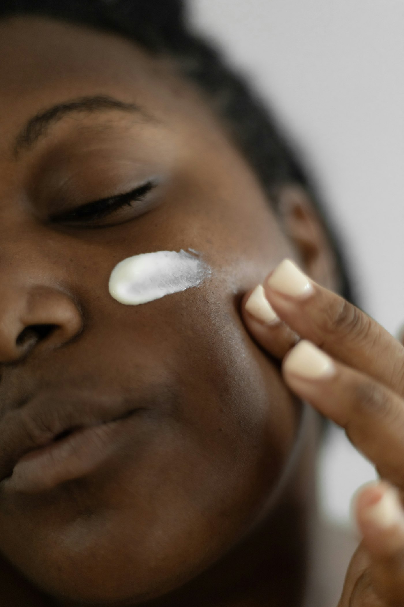 Woman applying facial cream, the everyday routine at the centre of the spf moisturiser vs sunscreen question
