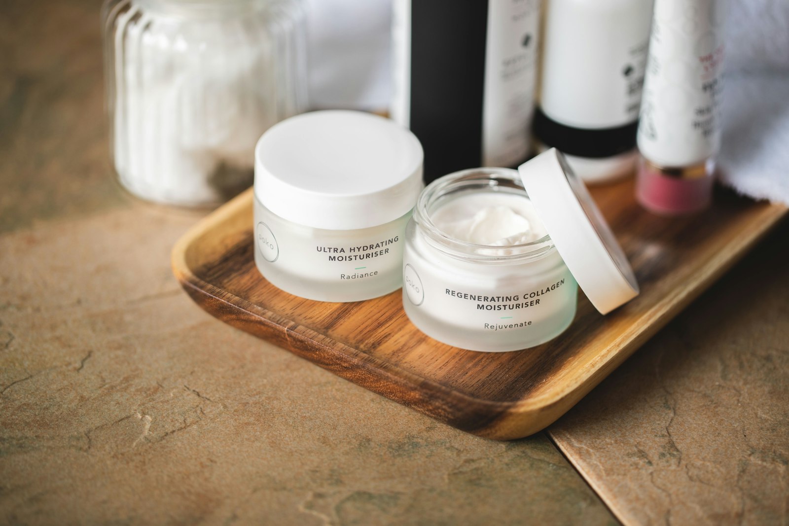 Jars of hydrating moisturiser on a wooden tray - the kind of SPF moisturiser product many people rely on instead of sunscreen