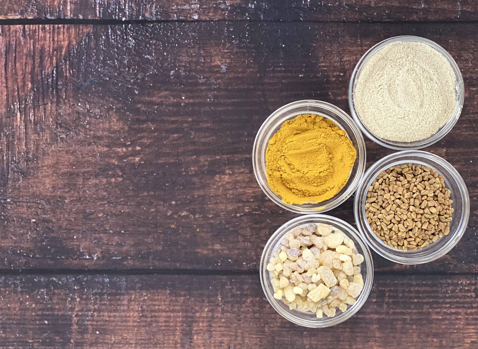 Ayurvedic herbs and powders including ashwagandha laid out in bowls