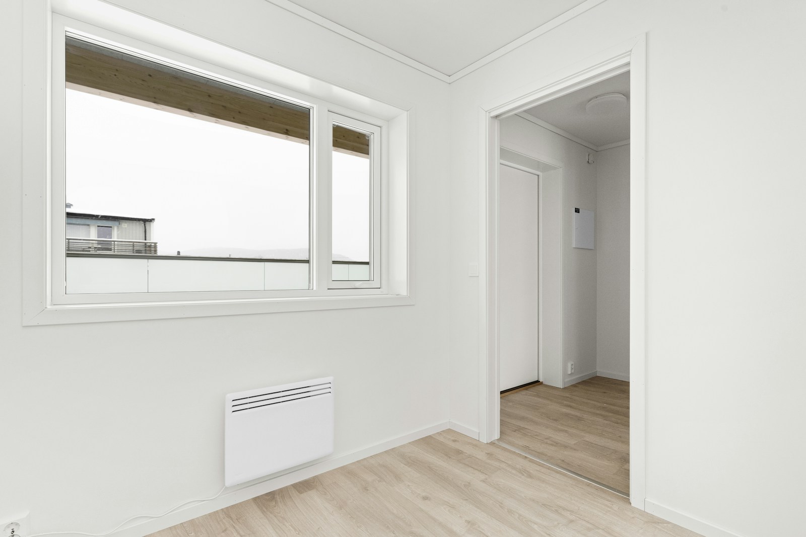 An empty room with a window and a heater, the kind of cold space where the best dehumidifier for damp earns its keep