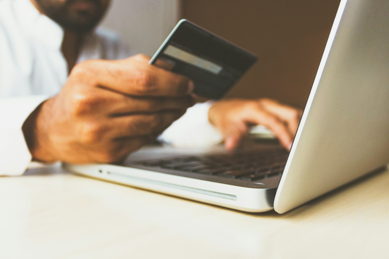 Person shopping online with a laptop and bank card