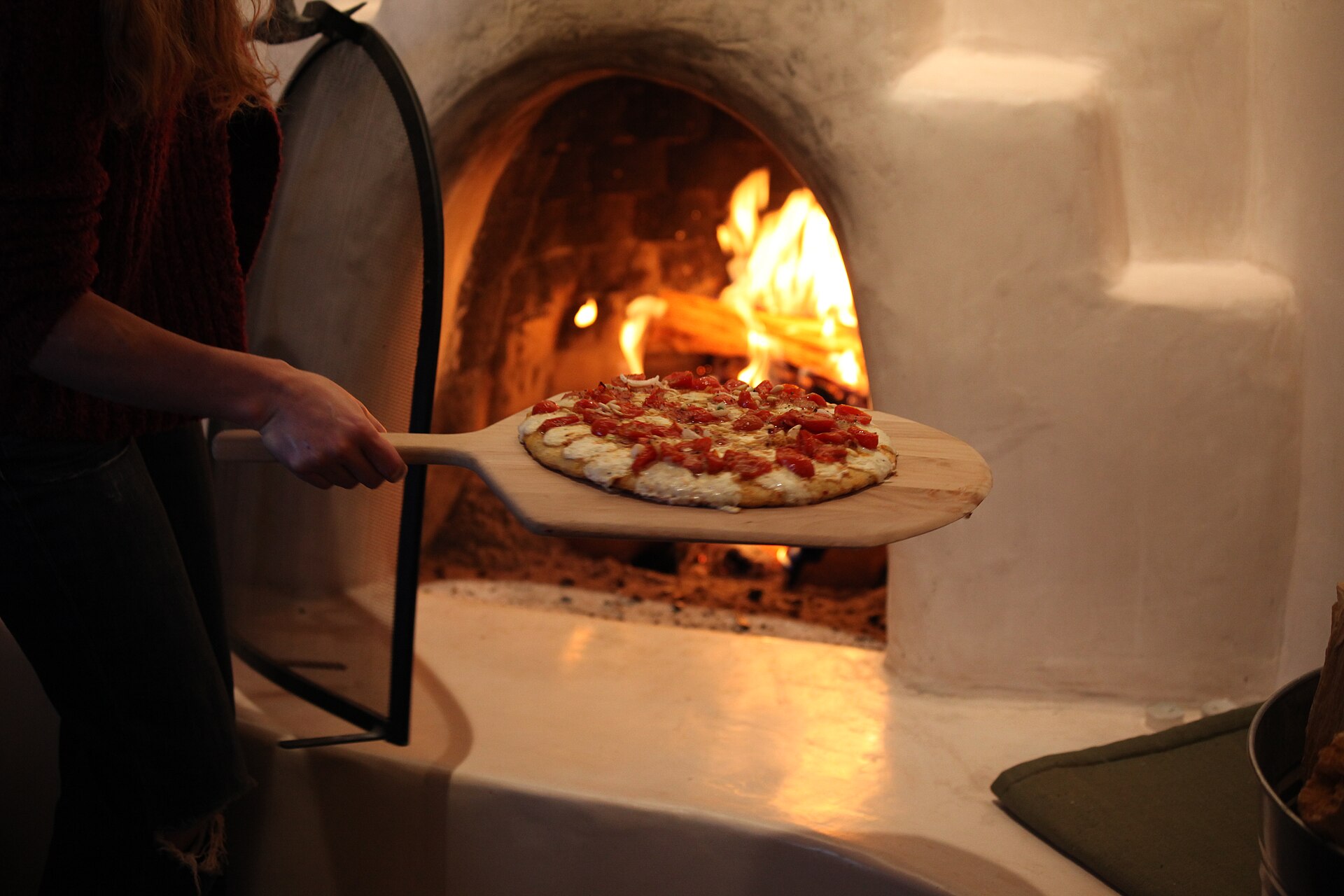 Launching a pizza from a wooden peel into a hot domestic pizza oven