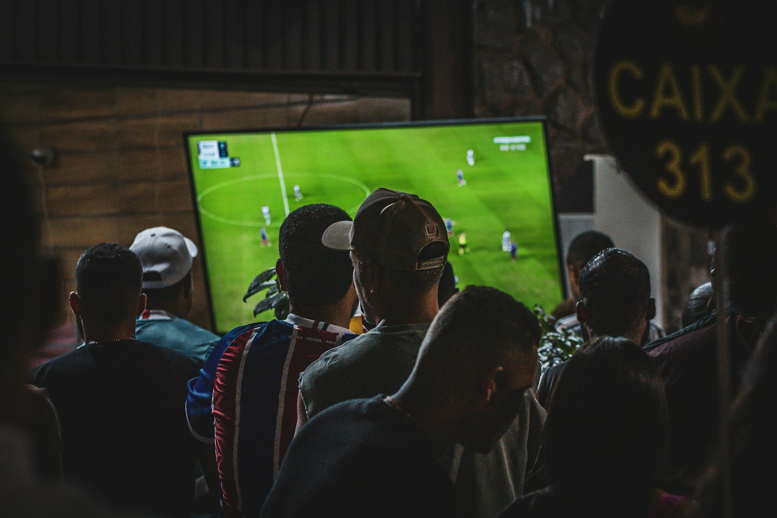 Friends watching a football match on TV at home