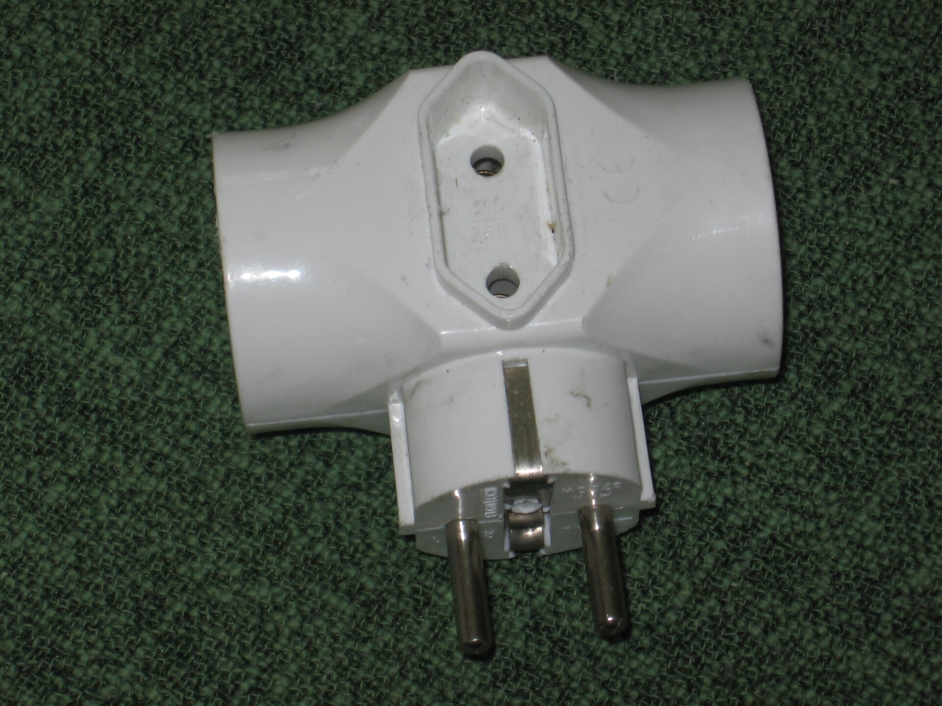 A UK three-pin plug beside wall sockets