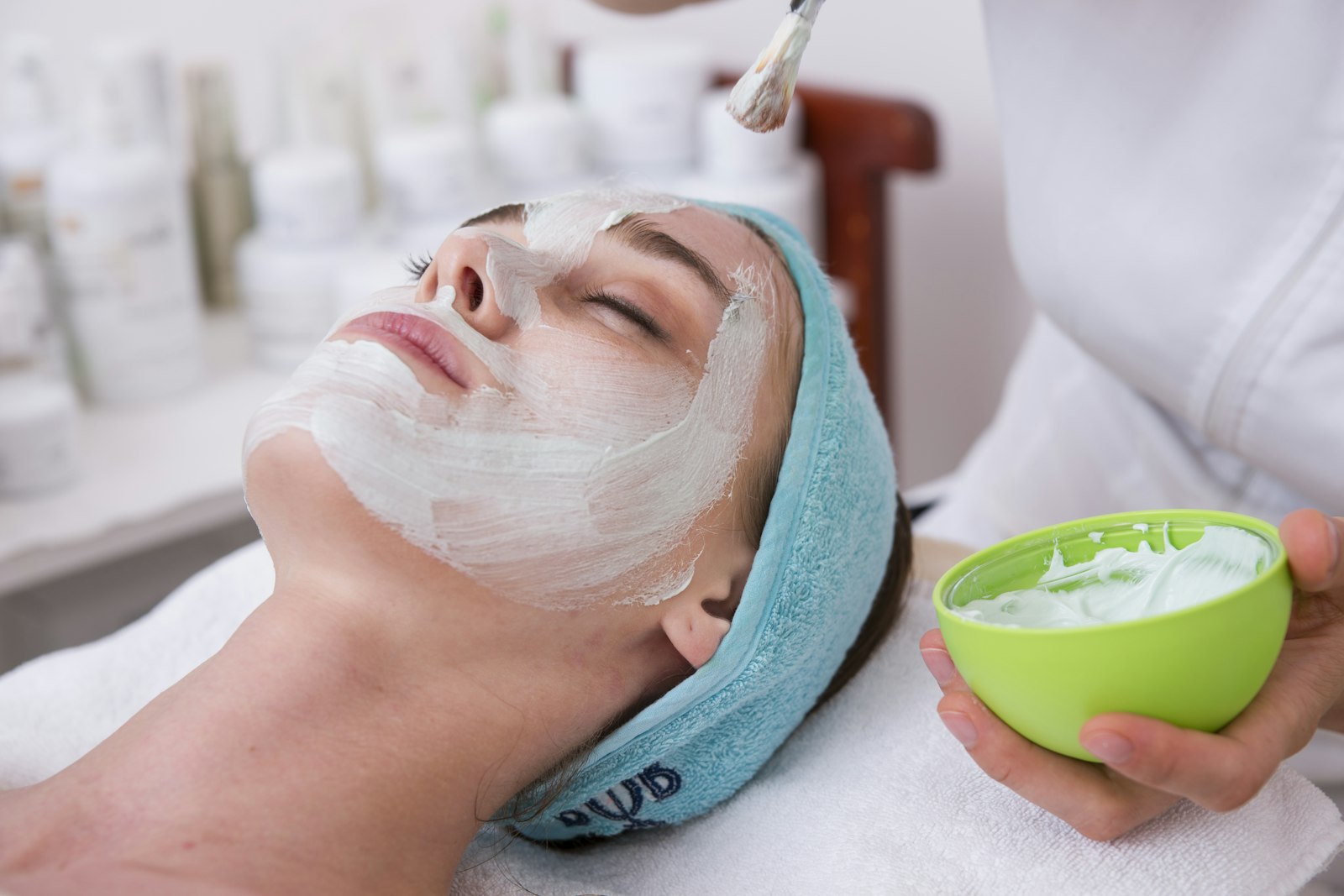 Calming botanical face mask being applied with a brush during a facial treatment