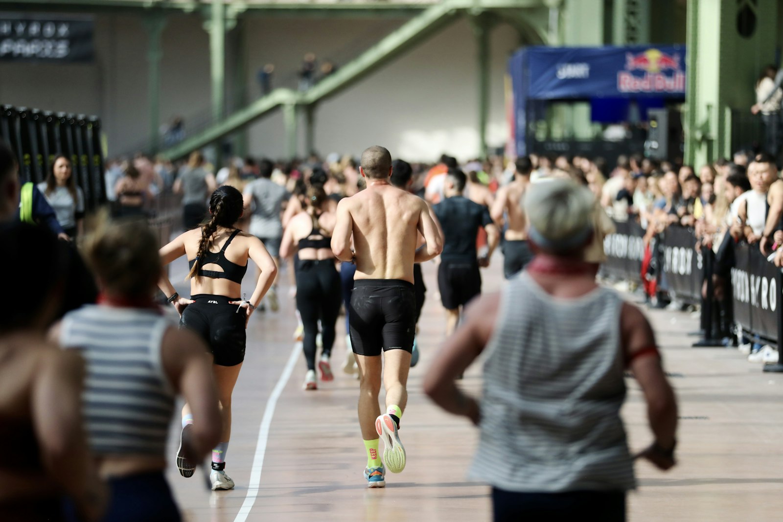 Athletes running between stations at an indoor Hyrox race event