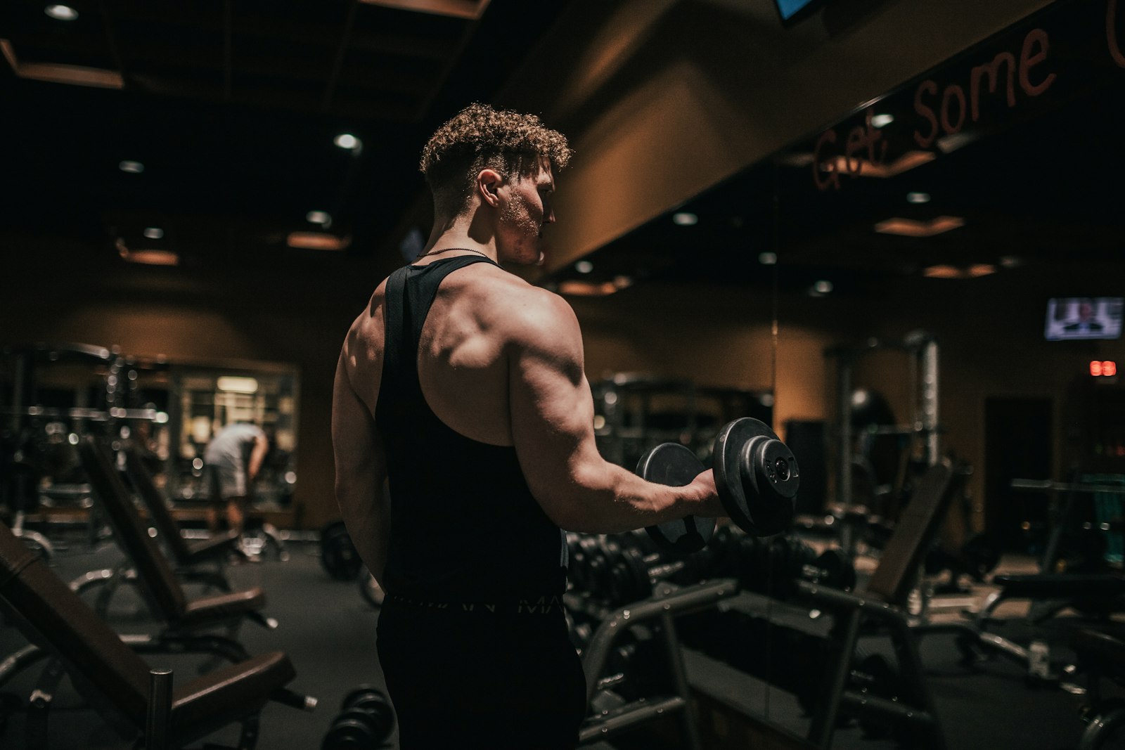 Man training with a dumbbell in a gym - shilajit's audience is the same crowd that adopted tongkat ali and creatine