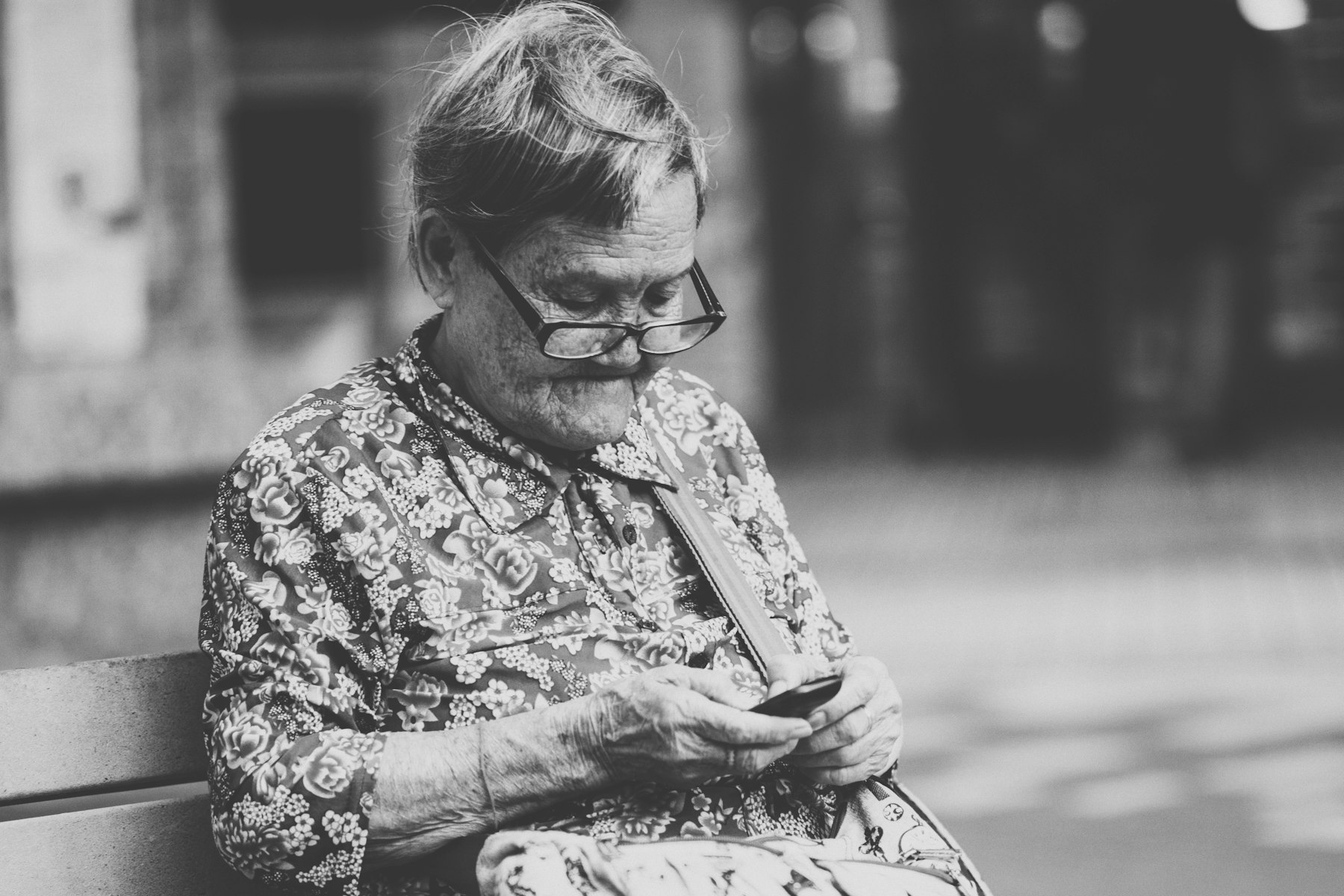 An older woman talking on a corded telephone at home