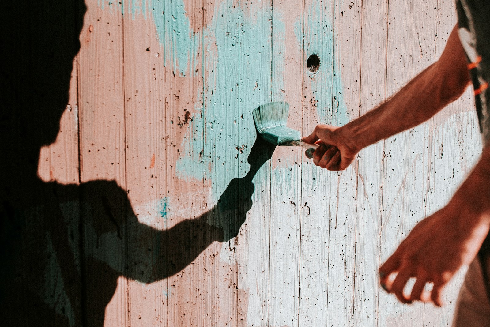 Decorator applying paint to an interior wall with a brush