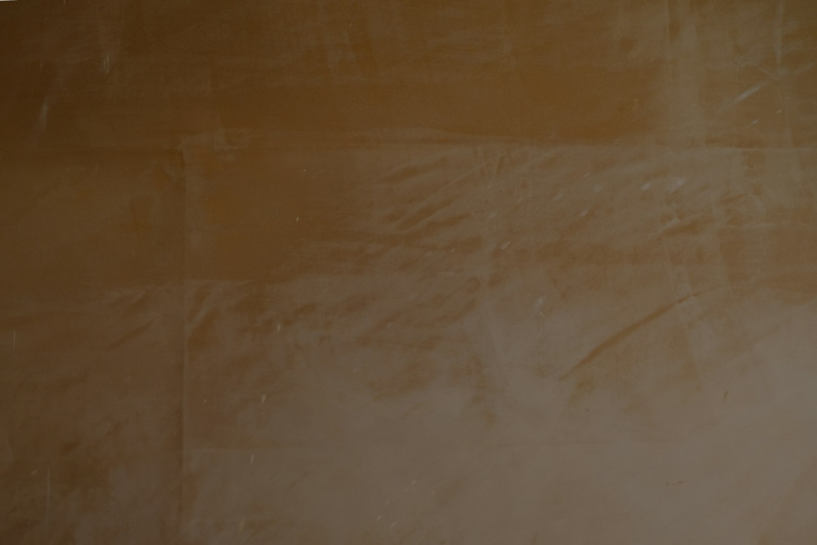 Warm brown textured wall surface in raking light