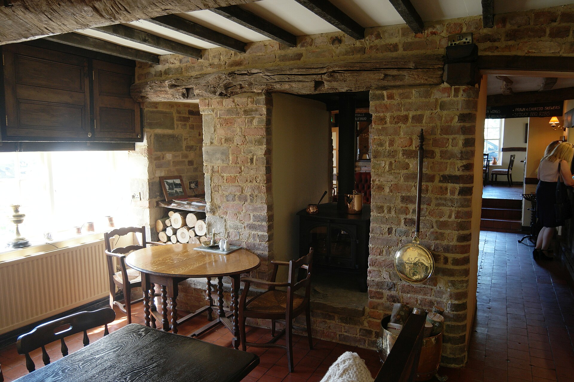 A wood burning stove set into a brick chimney breast in an English pub interior