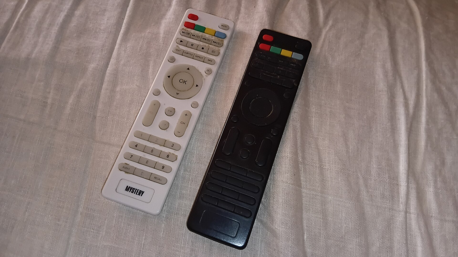 Two television remote controls side by side on a table