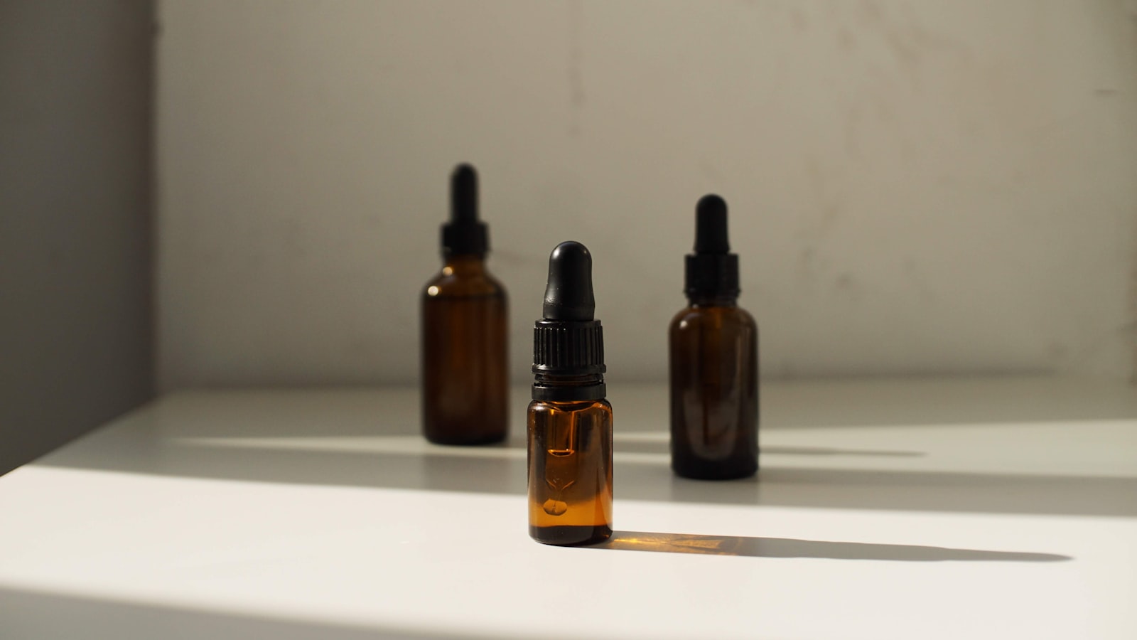 Amber glass tincture bottles lined up on a shelf, the format used for the lymphatic drainage drops trending on TikTok