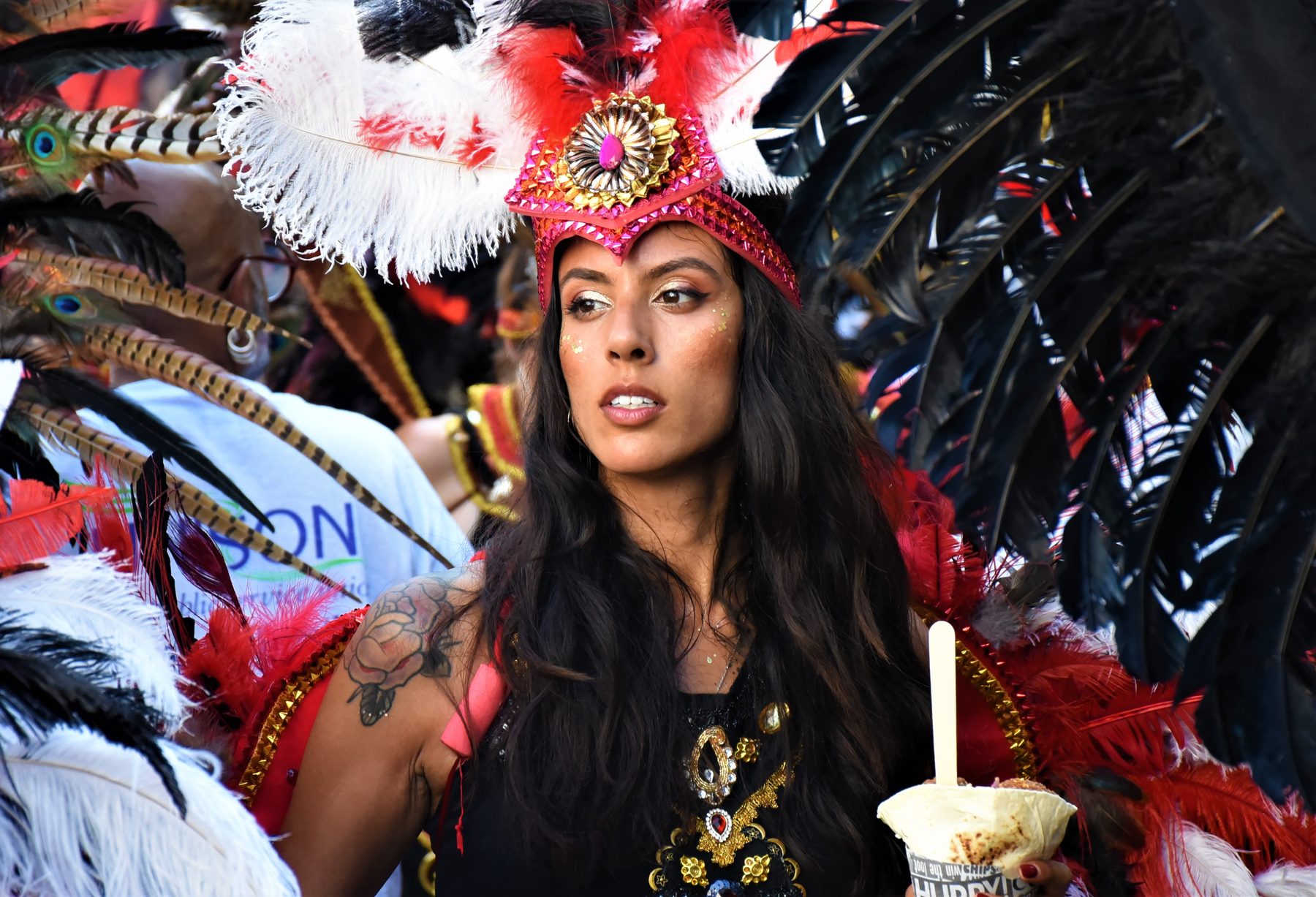 Carnival performer in full costume dancing in front of the parade crowds in west London