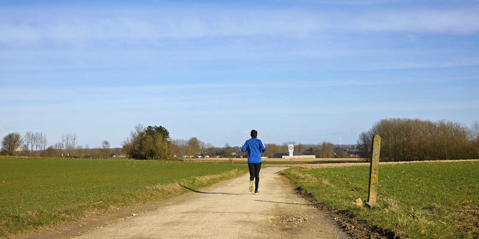 Runner on a long training run through green countryside in August
