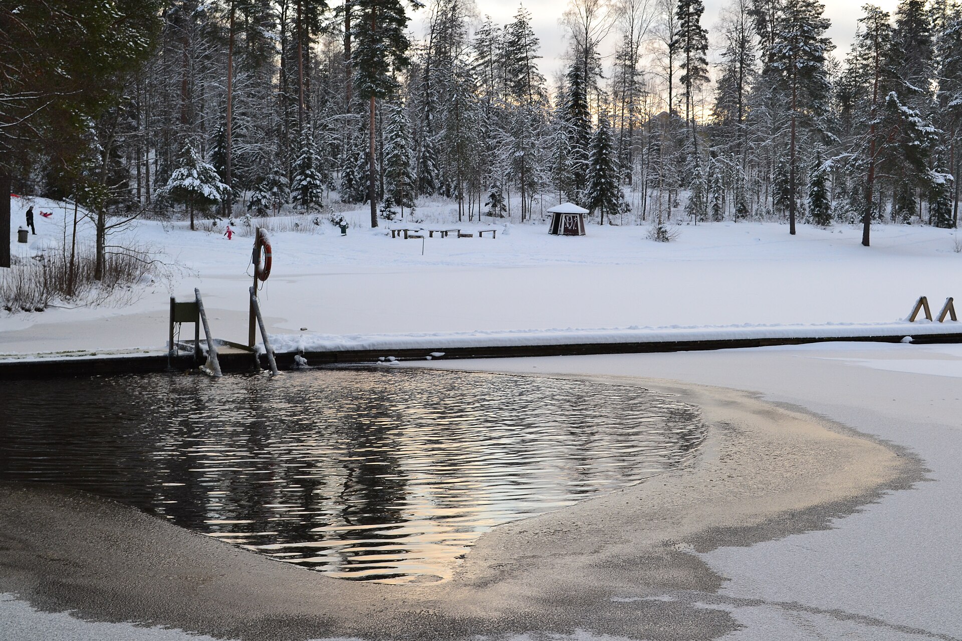 A winter swimming spot on a frozen Finnish lake, used for post-sauna cool-downs