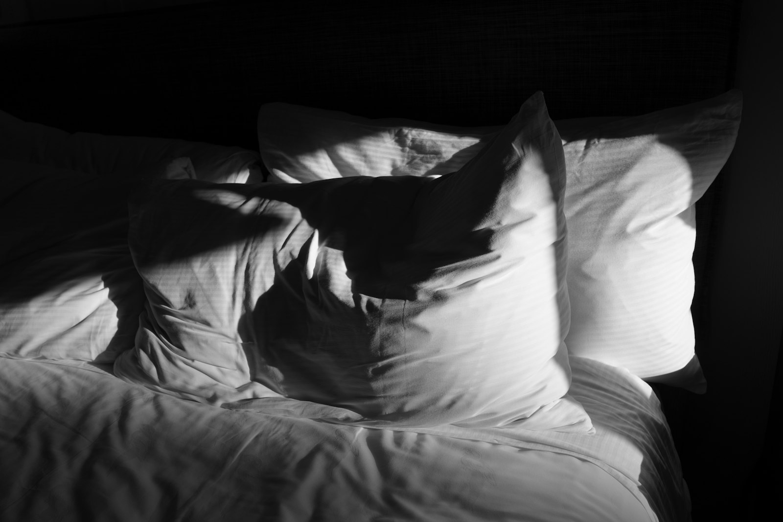 Morning sunlight falling across white bedding - better sleep is the first Sober September benefit most people notice