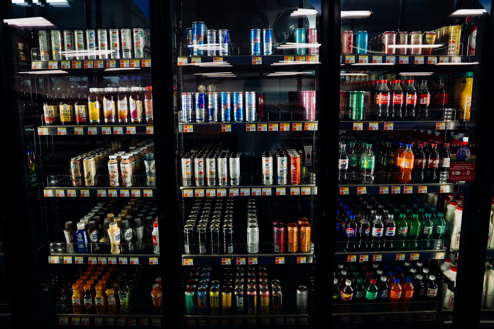 Supermarket fridge shelves stocked with soft drinks and alcohol-free alternatives