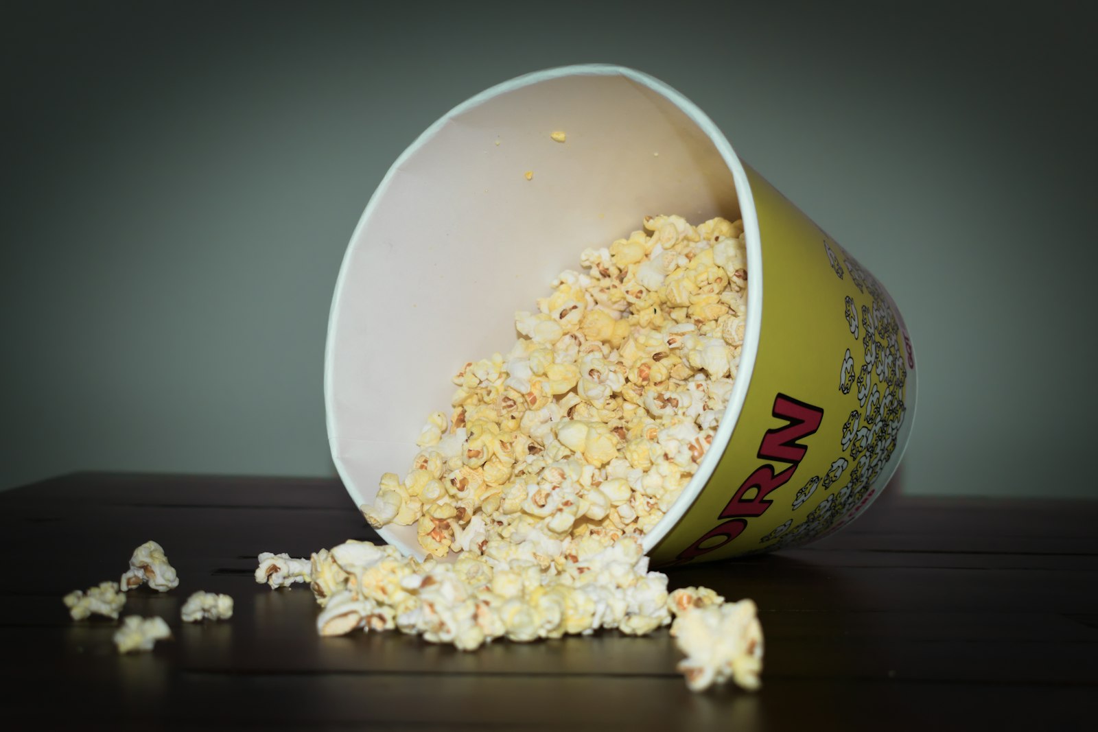 Popcorn being poured into a striped cup - the snack counter is where a cinema trip becomes an £80 family outing