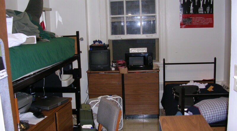 Uni room essentials in a typical student halls bedroom with bed, desk and storage