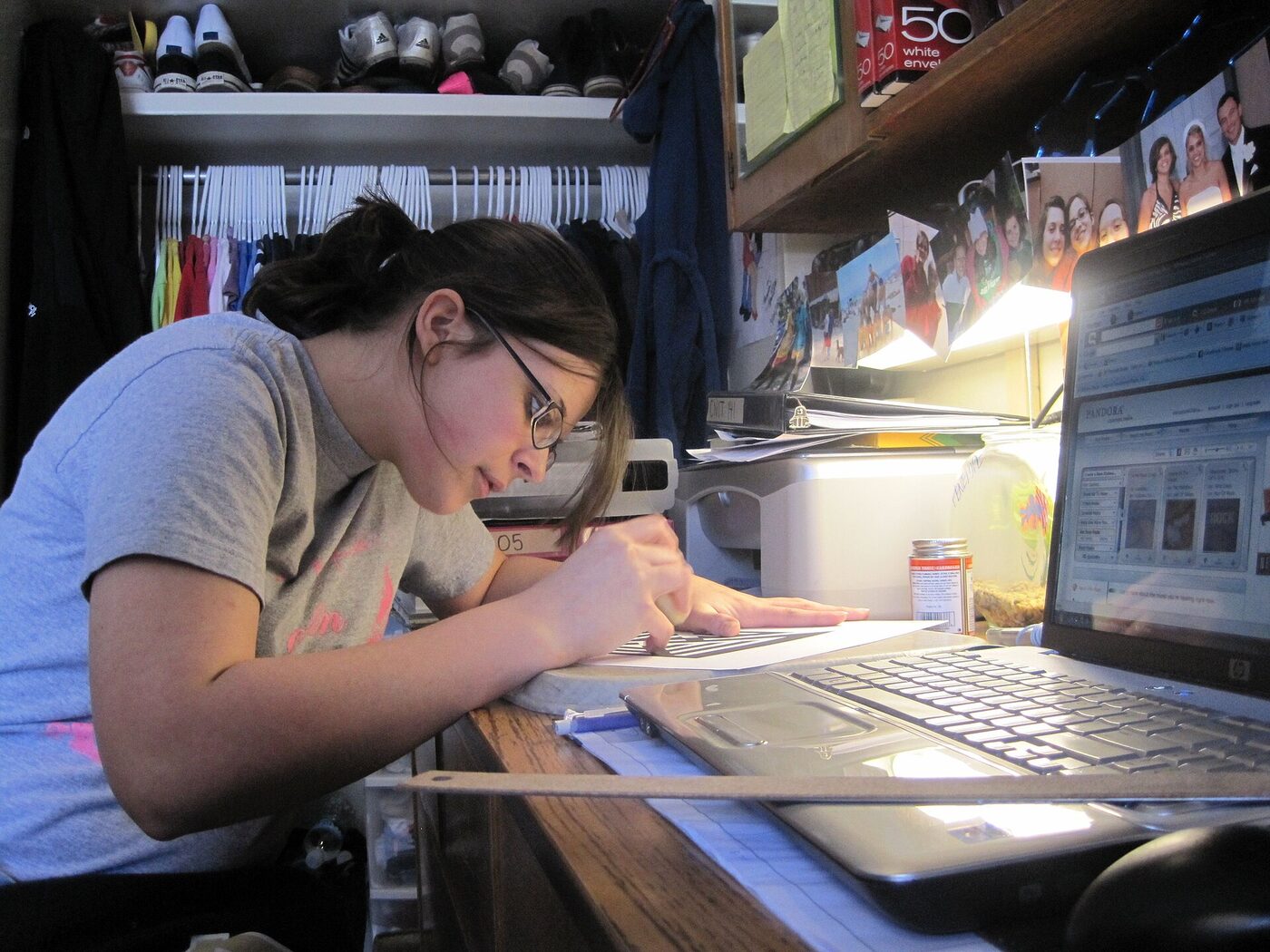 Student working at a halls desk by lamplight with a laptop