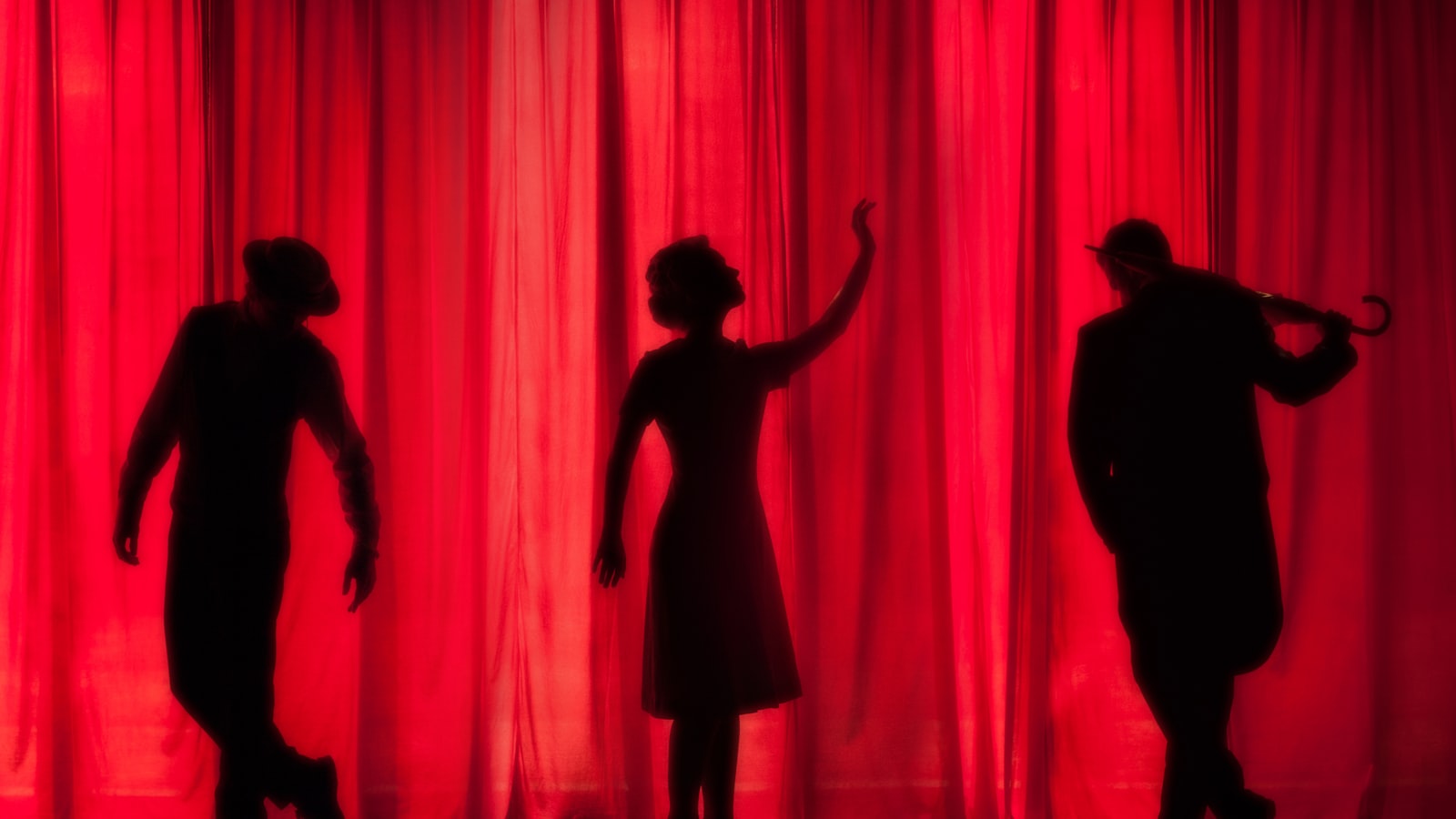 Silhouetted performers behind a red theatre curtain - the Van Morrison tour 2026 favours seated halls and theatres over arenas