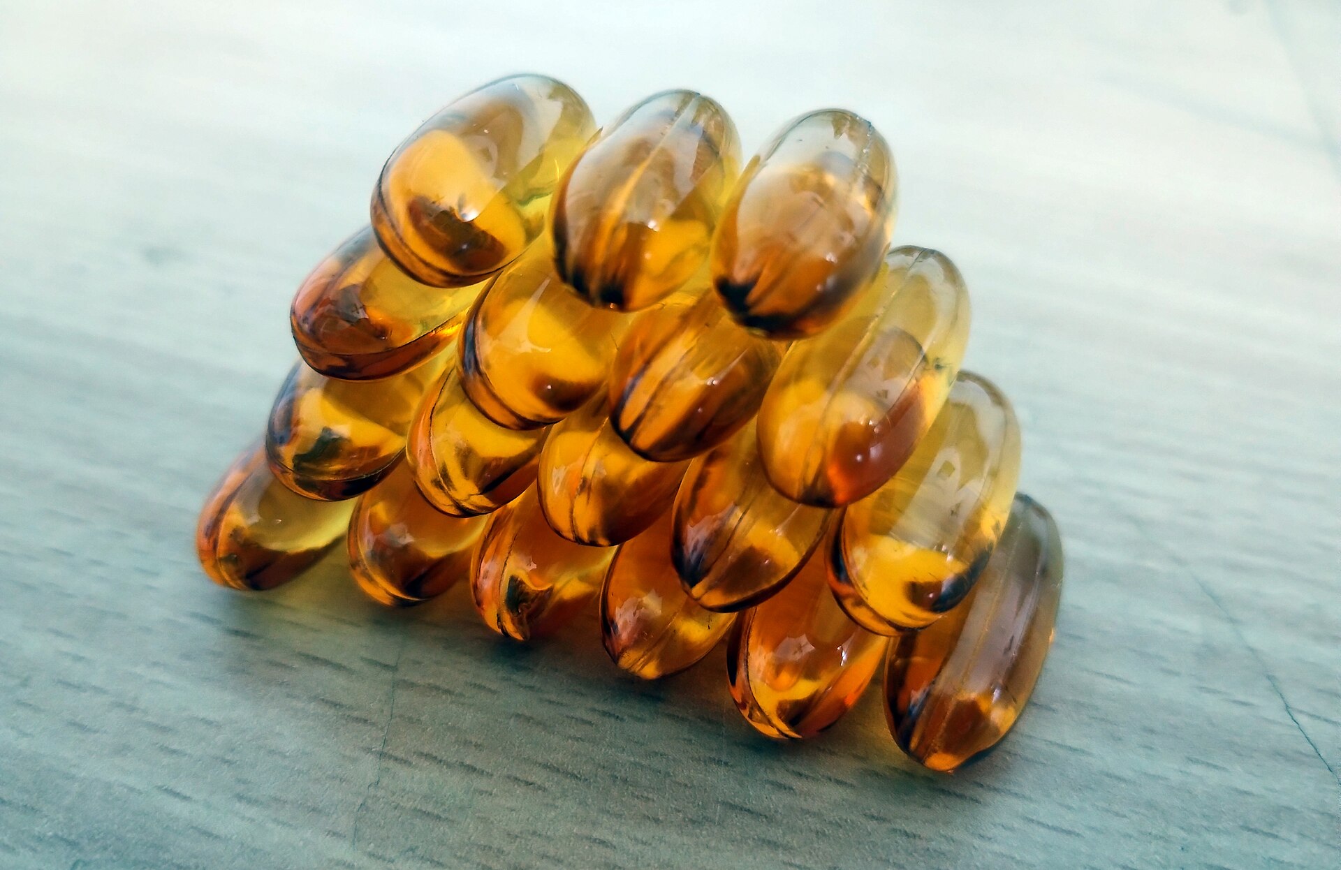 Vitamin D in winter comes from a supplement for most Britons - amber softgel capsules stacked on a pale wooden table