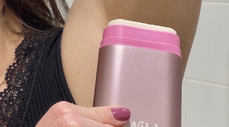 applying Wild natural deodorant stick to underarm