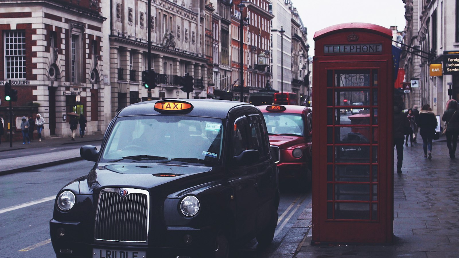 A London black cab parked beside a red telephone box