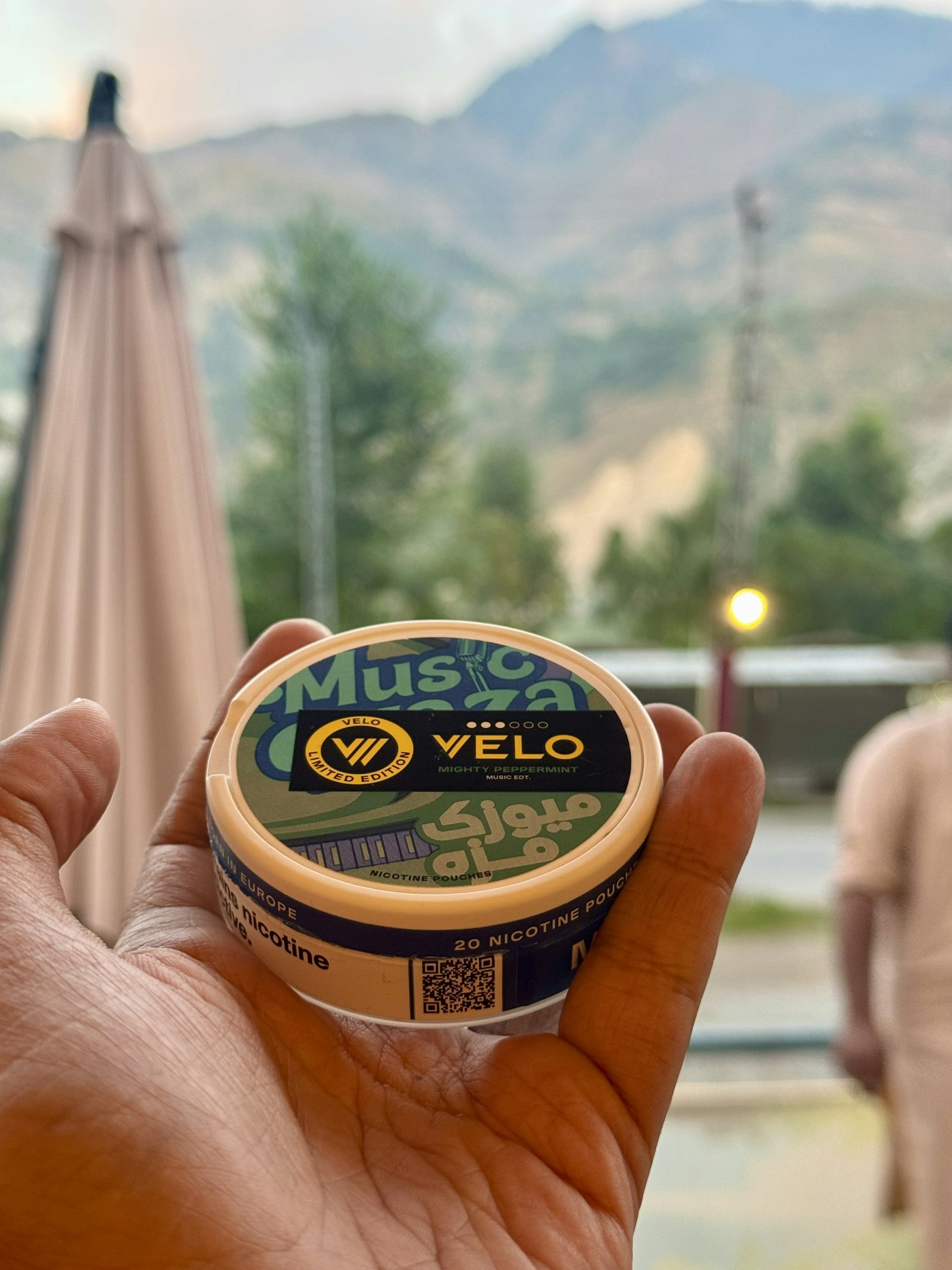 Hand holding a tin of nicotine pouches outdoors - are nicotine pouches safe is the question 770,000 British users are asking