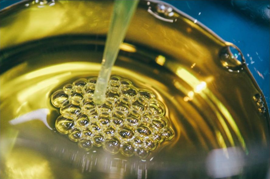 Close-up of golden cooking oil being poured, the kind of seed oil at the centre of the are seed oils bad for you debate