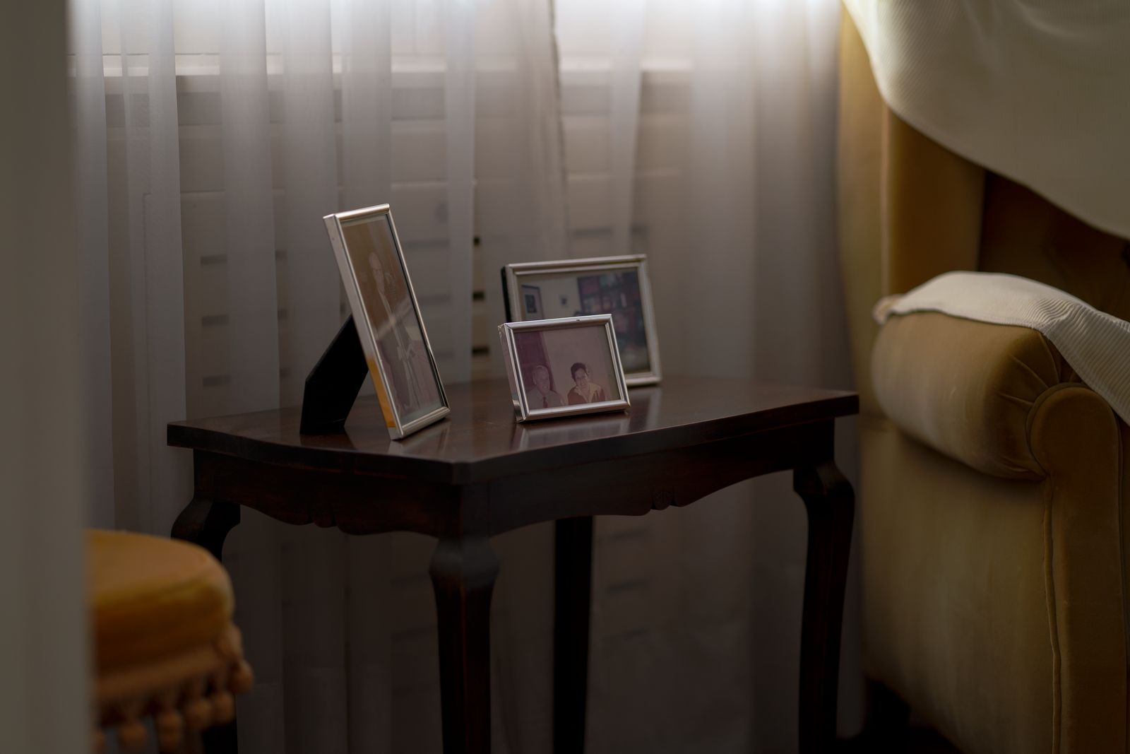 Digital photo frame displaying family photos on a wooden sideboard