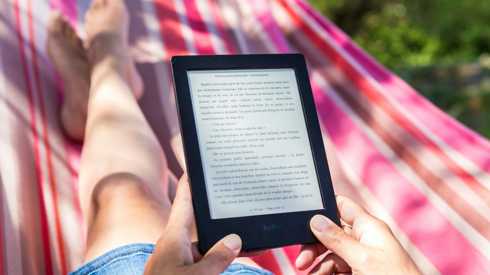 Person reading on an e-reader in low light, one of the cheapest ways to read after the clocks go back