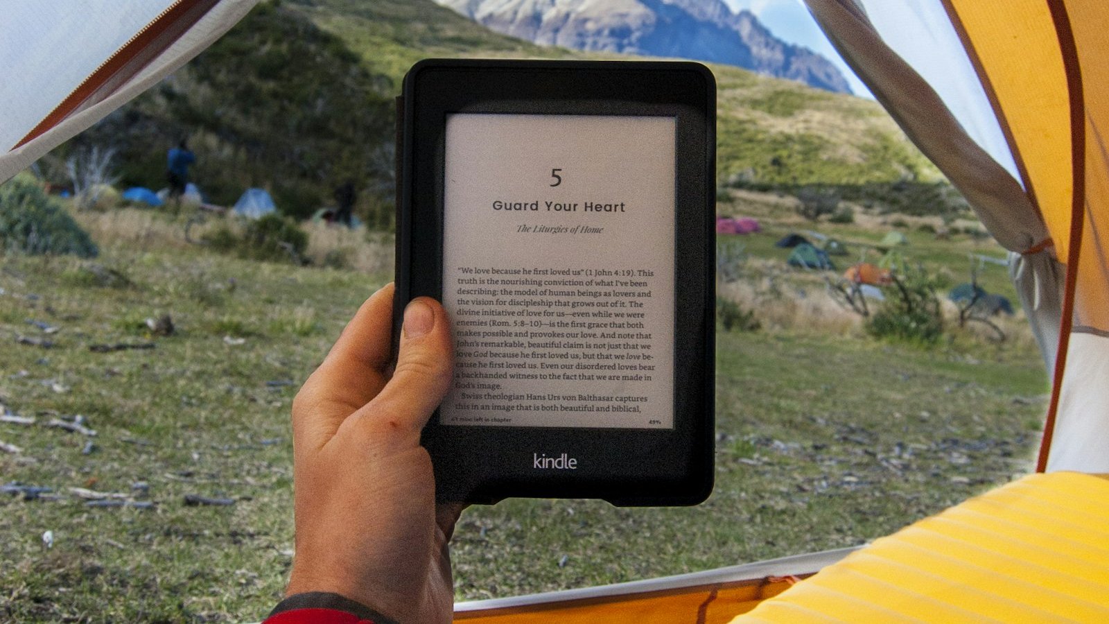 Reading a Kindle from inside a tent, an e-reader travels lighter than a stack of paperbacks