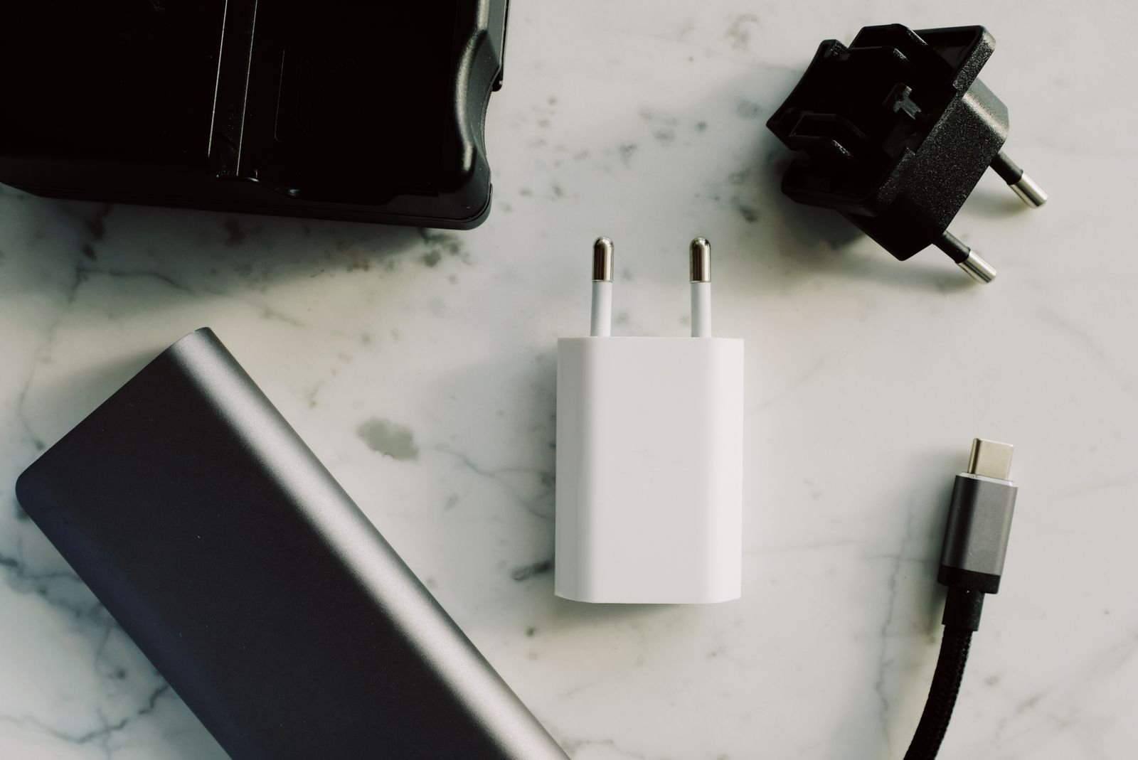 Travel adapter, USB-C cable and power bank packed together for a half term flight