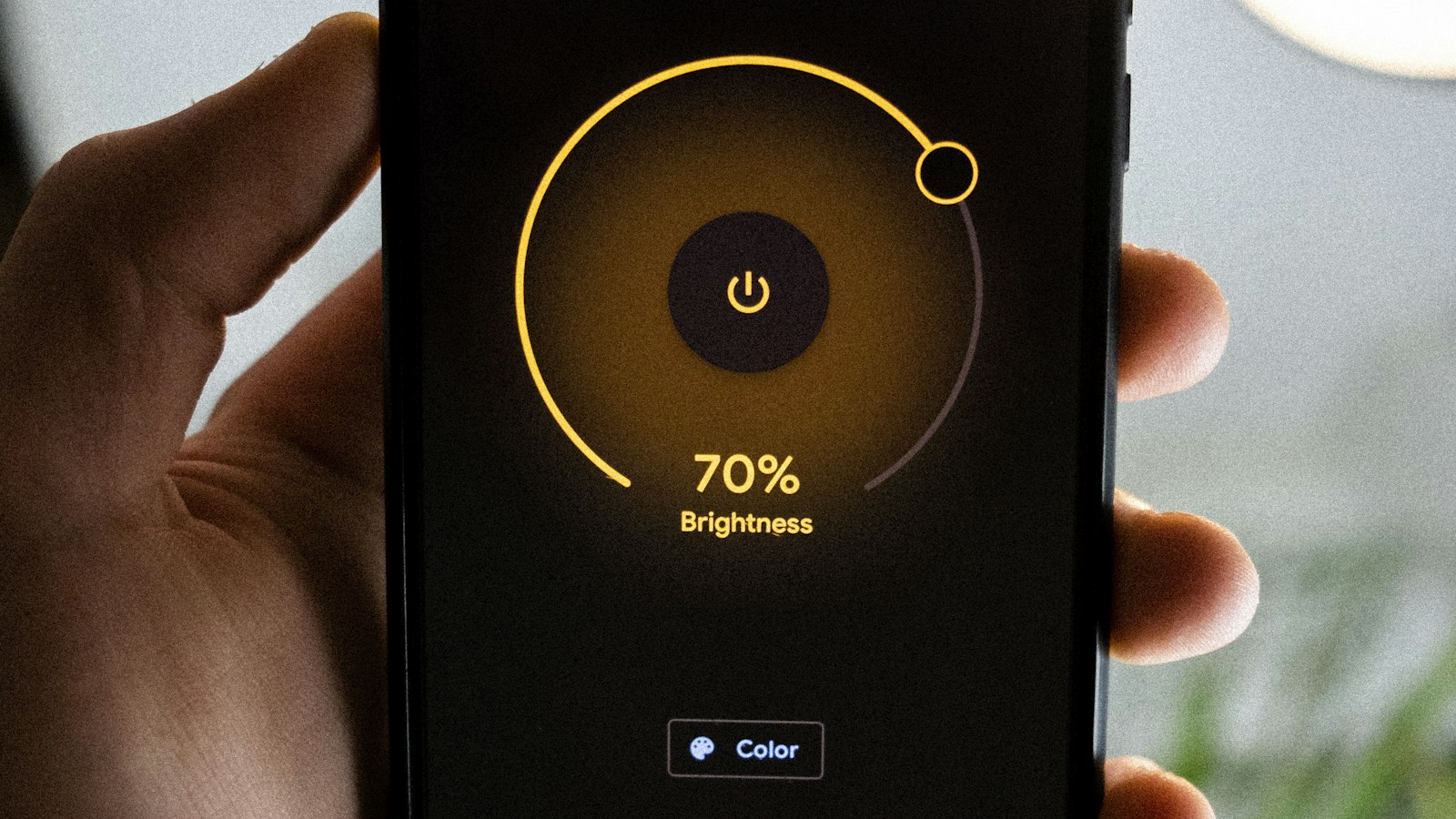Person holding a smartphone to control home heating from an app