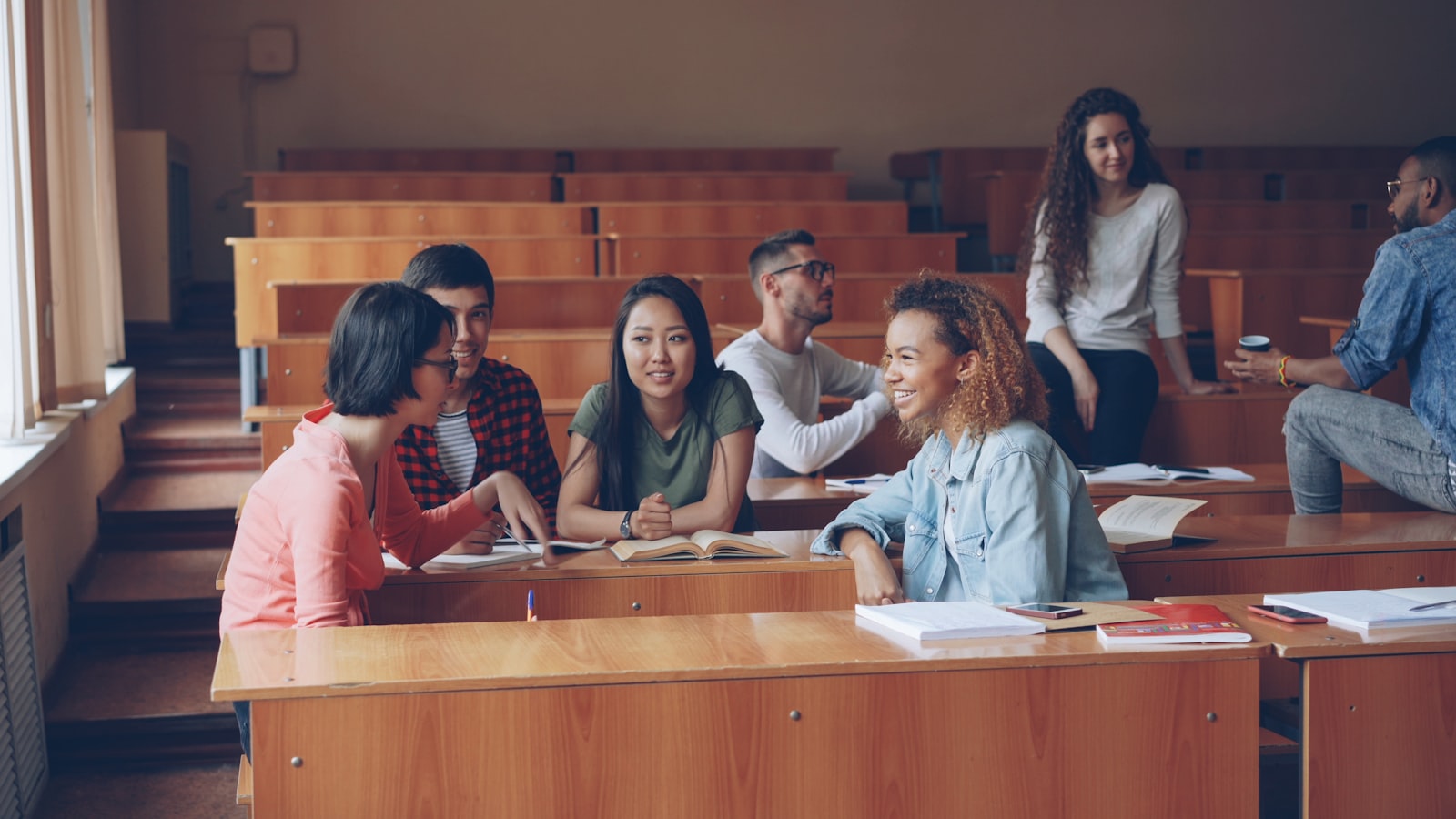 Students talking and working in a university lecture hall