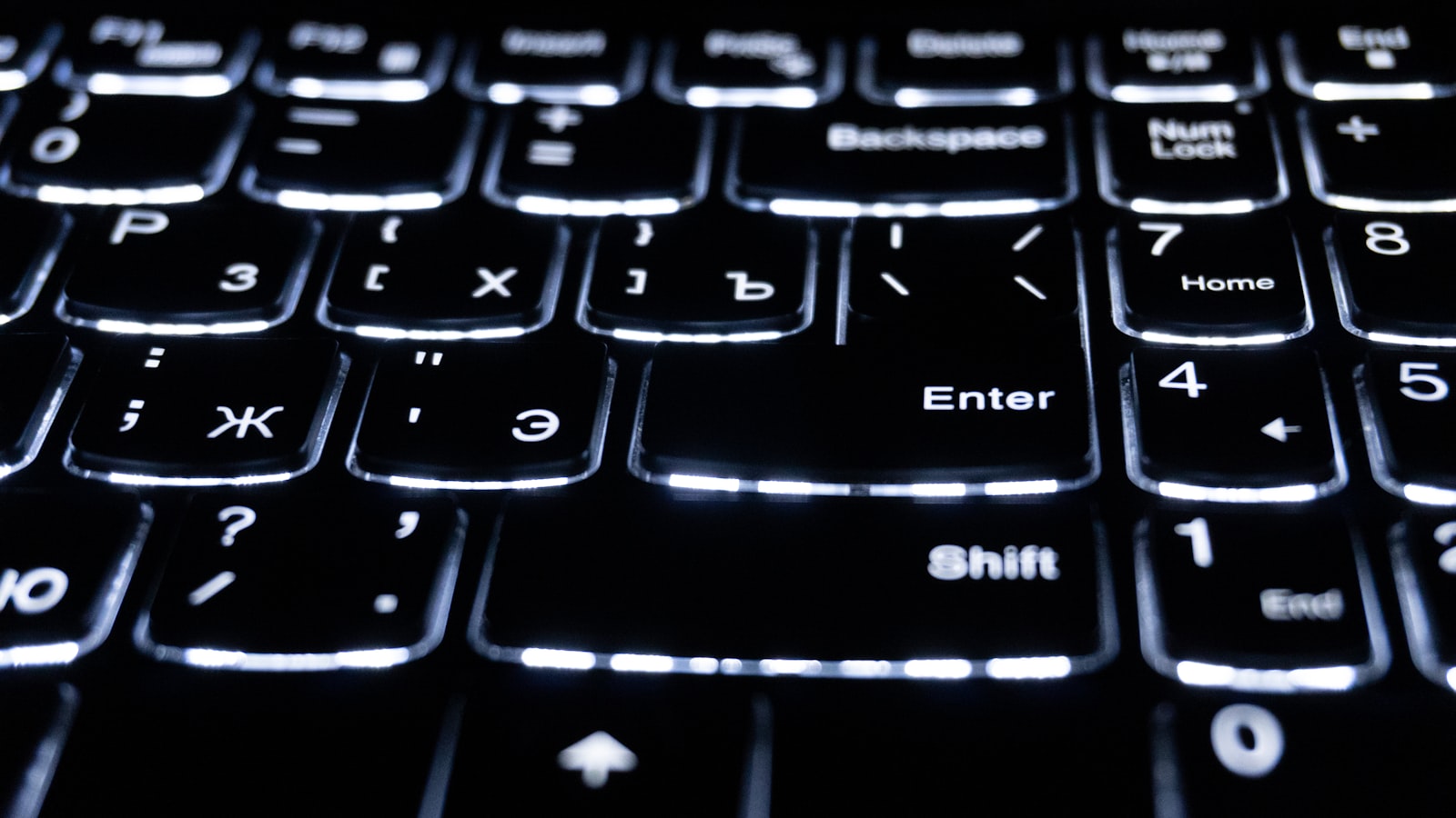 Close-up of a backlit laptop keyboard glowing in low light - a feature the MacBook Neo leaves out
