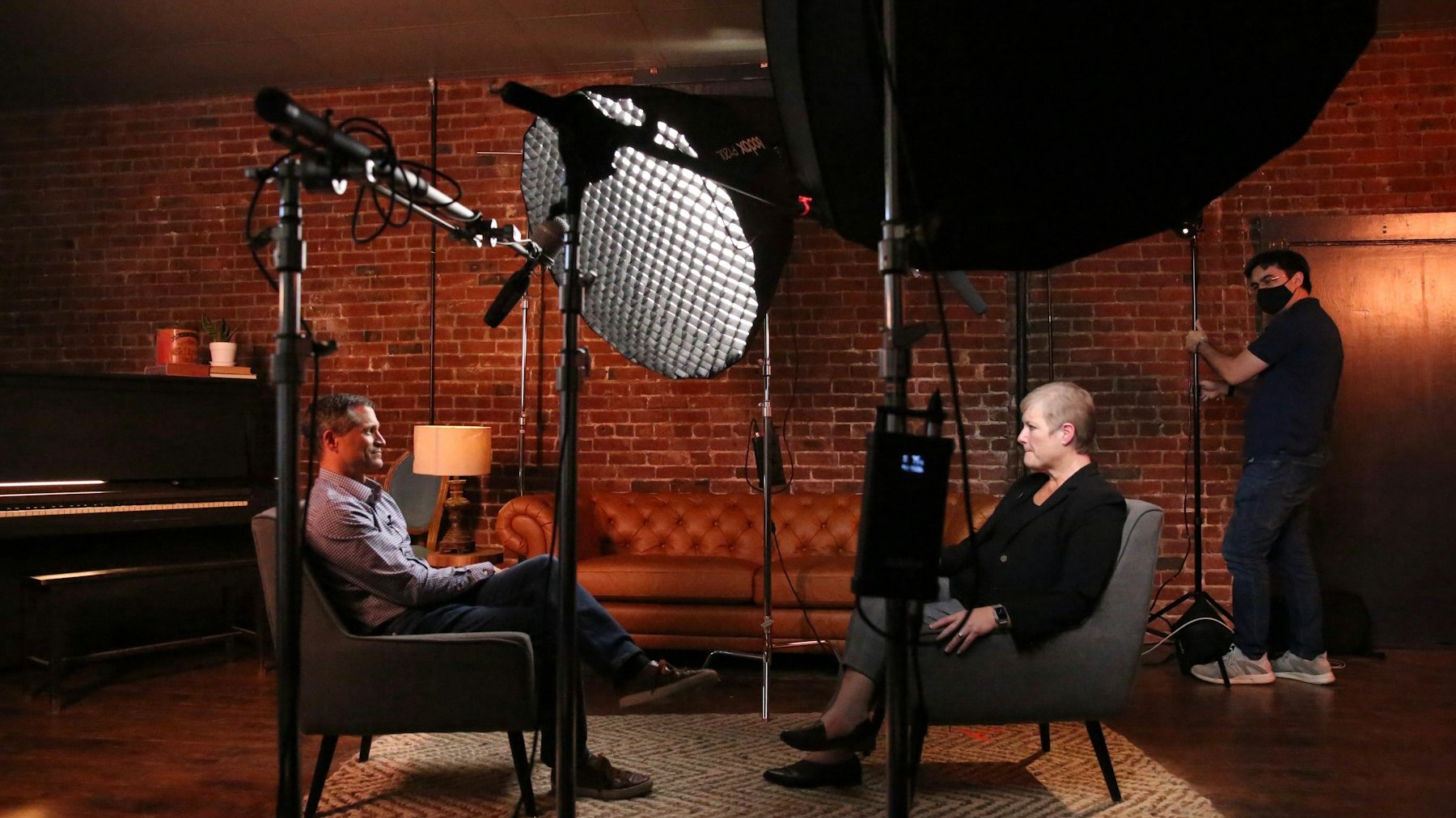 Two presenters on chairs in front of a studio camera and lights, a set-up close to Big Brother: The Group Chat